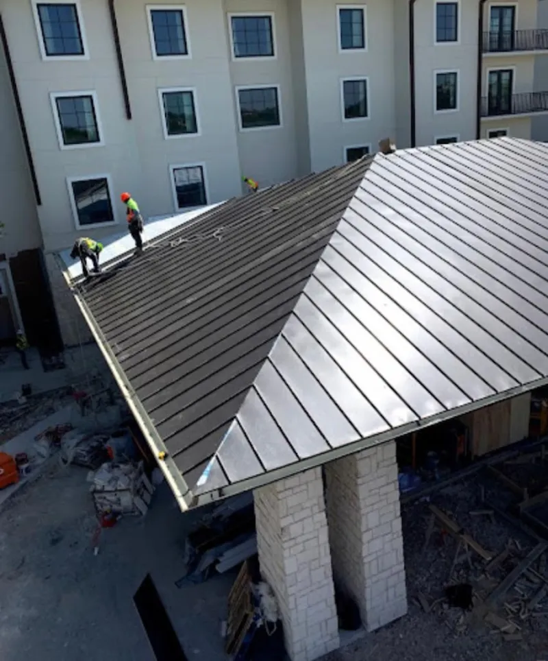 Crew installing standing seam metal roof panels on a commercial project in Chula Vista